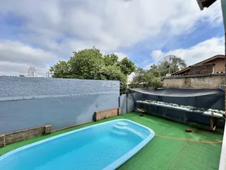 Foto de uma piscina externa em um quintal.