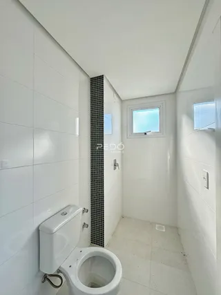 Foto de um banheiro com revestimento cerâmico branco.