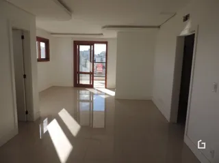 Interior de uma sala com piso claro e paredes brancas.