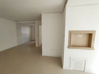 Hall de entrada com paredes brancas e piso claro.