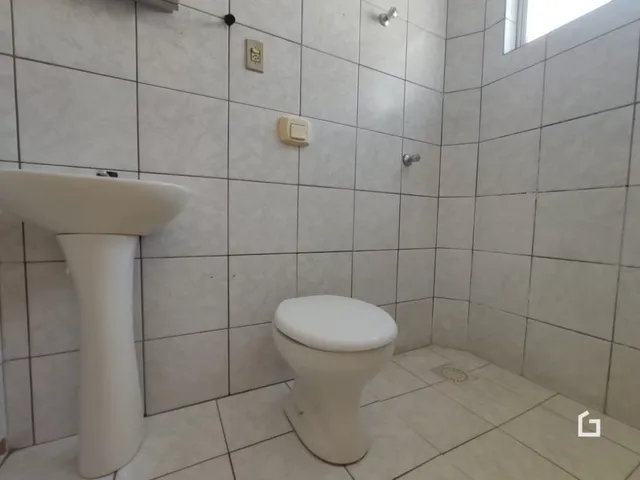 A foto mostra o interior de um banheiro com azulejos brancos.