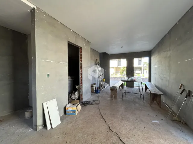 Interior de uma sala em construção com paredes de concreto aparente.