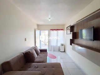 Foto de uma sala de estar com sofá e televisão montada na parede.