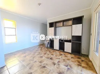 Foto de uma sala com piso de cerâmica e estante embutida na parede.
