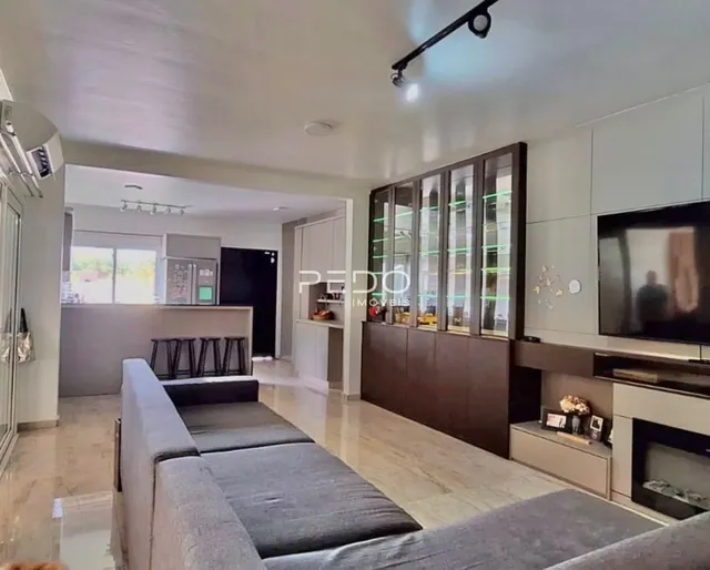 Sala de estar com sofá e painel de madeira na residência.