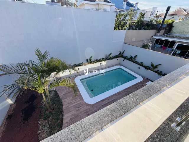 Vista de uma piscina e jardim em uma propriedade.