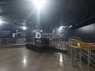 Imagem de um corredor com piso de cerâmica e grades de metal.
