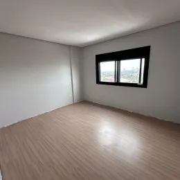 Foto de um cômodo interno com piso de madeira clara e janela.
