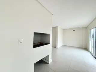 Foto de um ambiente interno amplo com paredes brancas e piso de cerâmica.