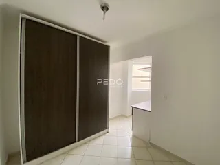 Interior de um cômodo com piso de cerâmica e portas de correr escuras.