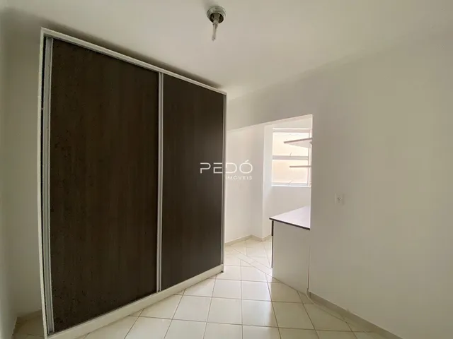 Interior de um cômodo com piso de cerâmica e portas de correr escuras.