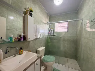 Banheiro com box de vidro e azulejos nas paredes