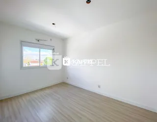 Foto de um cômodo interno com piso de madeira e janela.