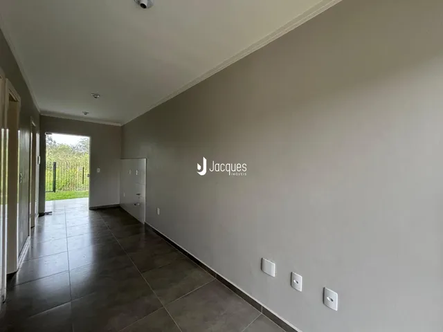 Corredor interno de uma residência com piso de cerâmica.
