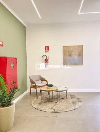 Sala de estar com poltrona e mesa de centro em um ambiente claro.