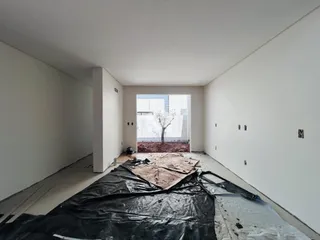 Um cômodo interno está em fase de reforma com piso exposto.