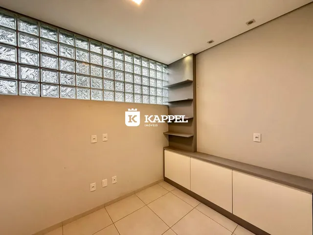 Sala de estar com parede de vidro decorativo e estantes embutidas.
