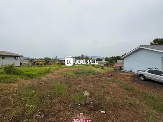 Vista externa de um terreno com vegetação seca e solo exposto.