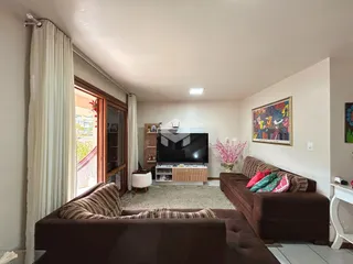 Sala de estar com sofá e janela de madeira.