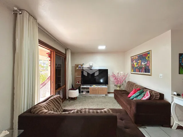 Sala de estar com sofá e janela de madeira.