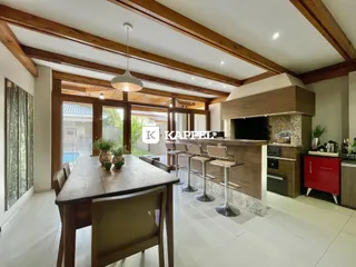 Sala de jantar com mesa de madeira e acesso a área externa.