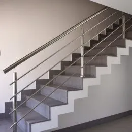 Escadaria com corrimão de metal em um ambiente interno.
