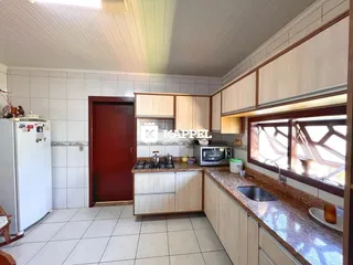 Cozinha com armários de madeira e piso de cerâmica.