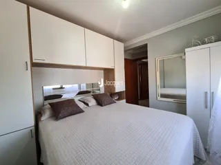 Quarto com cama e armários embutidos brancos.