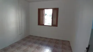 Foto de um cômodo interno com piso de madeira e uma janela.