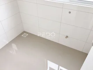 Canto de um ambiente interno com piso e paredes brancas de cerâmica.