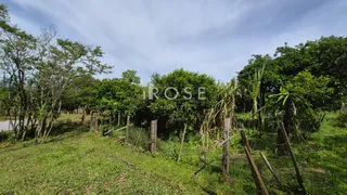 Campo gramado com cerca de madeira em uma propriedade rural.