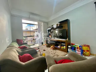 Sala de estar com sofá e móveis em ambiente interno.