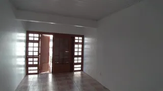 Hall de entrada com portas de madeira e piso de madeira.