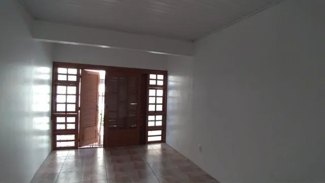 Hall de entrada com portas de madeira e piso de madeira.