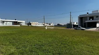 Vista externa de uma propriedade com gramado em primeiro plano e edifícios ao fundo.