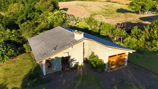 Vista aérea da fachada de uma casa em Lajeado, Brasil, com telhado inclinado e garagem de madeira.