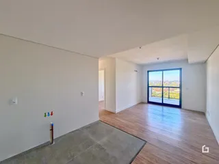 Sala de estar com piso de madeira e grande janela com vista para a paisagem.
