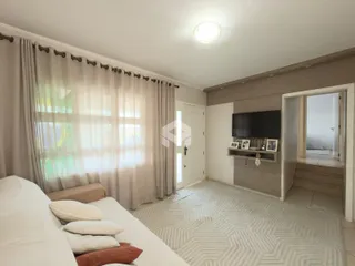 Quarto com cortinas e vista pela janela.