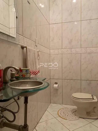 Foto do interior de um banheiro com revestimento de azulejos claros.