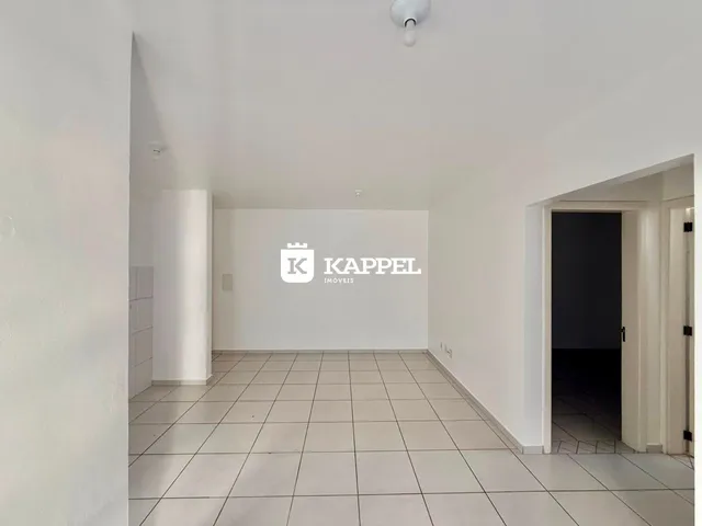 Foto de um ambiente interno com piso de cerâmica claro e paredes brancas.