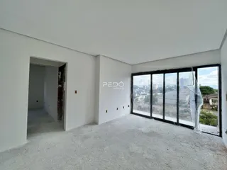 Interior de um cômodo com paredes brancas e piso de concreto cru.