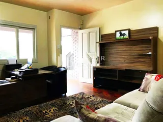 Sala de estar com piso de madeira e tapete.