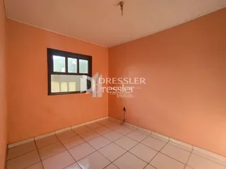 Interior de um cômodo com paredes alaranjadas e piso de cerâmica.