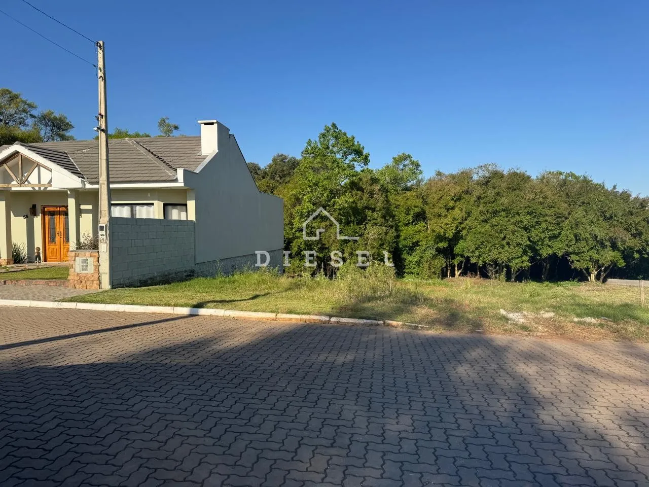 Fachada de uma casa em Lajeado, Brasil, com jardim e área pavimentada na frente.