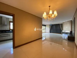 Ambiente interno de uma sala com piso claro e paredes bege.