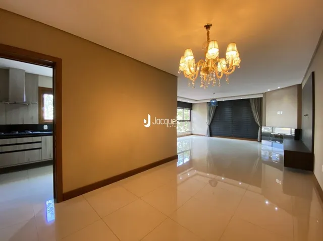 Ambiente interno de uma sala com piso claro e paredes bege.