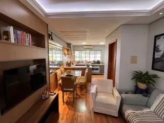 Sala de estar com televisão e acabamentos em madeira.