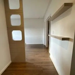 Hall de entrada com painéis de madeira e piso de madeira.