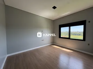 Sala de estar com piso de madeira e grande janela com vista para a paisagem.