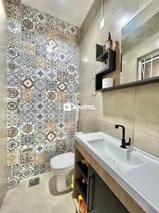 Foto de um banheiro com revestimento de azulejos e bancada branca.
